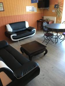 ein Wohnzimmer mit einem Sofa und einem Tisch in der Unterkunft Aux 3 Loups in Châtenois