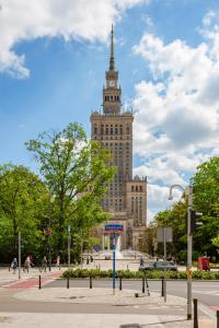 ワルシャワにあるApartments Warsaw Downtown Świętokrzyska by Rentersの時計塔のある大きな建物