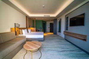 HVD Reina del Mar - Premium Spa Service & Free Parking في ابزور: غرفة فندق بها سرير وأريكة وطاولة