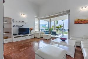 a living room with white furniture and a flat screen tv at Villa Eleonora, Luxury Villa with Heated Pool Ocean View in Adeje, Tenerife in Adeje