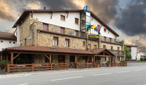 a large building on the side of a street at Hotel Rural Izar Ondo in Arbizu