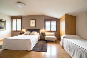 een slaapkamer met 2 bedden en een stoel bij Hotel Rural Izar Ondo in Arbizu