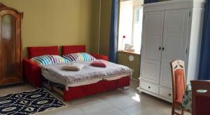 ein Schlafzimmer mit einem roten Bett mit Kissen darauf in der Unterkunft Eva's City Apartement in Waidhofen an der Ybbs