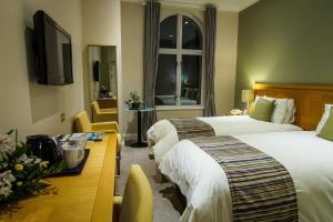 a hotel room with two beds and a television at Hotel de France in Saint Helier Jersey