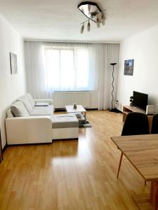 sala de estar con sofá blanco y mesa en Sunny Apartment, en Viena