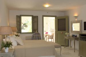 Saint Andrea Seaside Resort في ناوسا: غرفة نوم بسرير وطاولة ونوافذ