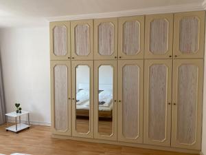 a bedroom with a large wardrobe with glass doors at Sunny Apartment in Vienna