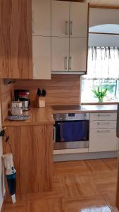 a kitchen with a stainless steel stove and wooden cabinets at Eva's City Apartement in Waidhofen an der Ybbs