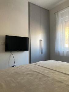 a bedroom with a bed and a flat screen tv at TAL in Tisno