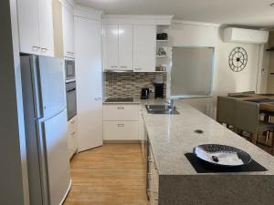 a kitchen with a sink, stove, and refrigerator at The Esplanade Riverview Holiday Apartments in Maroochydore