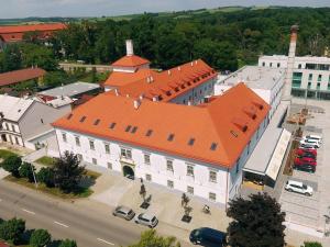 una vista sul soffitto di un grande edificio bianco con tetto arancione di Hotel Panský Pivovar a Holešov