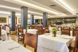 un comedor con mesas y sillas blancas en Hotel Rural Izar Ondo, en Arbizu