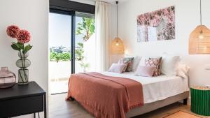 1 dormitorio con 1 cama grande con almohadas rosas en Luxe Apartments Hotel del Golf - Las Brisas Marbella, en Marbella