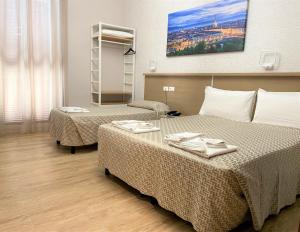 una camera d'albergo con due letti con tovaglioli sopra di Hotel Lo Scudiero a Torino