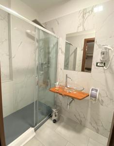 bagno con doccia in vetro e lavandino di Hotel Lo Scudiero a Torino