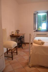 a room with two beds and a table and a chair at Val d'Orcia nel Borgo in Castiglione dʼOrcia