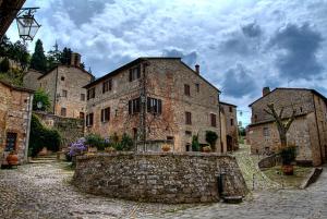 an old stone building on a cobblestone street at Val d'Orcia nel Borgo in Castiglione dʼOrcia