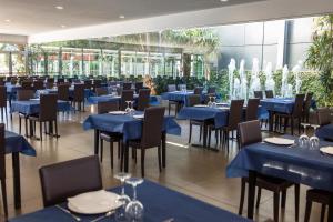a dining room with blue tables and chairs at RVHotels Nautic Park in Platja d'Aro