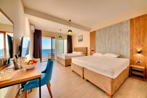 una camera d'albergo con due letti e un tavolo con un cesto di frutta di Sunset Hotel a Dobra Voda