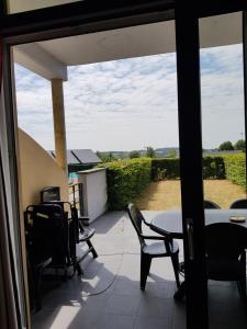 uma vista a partir da varanda de uma casa com uma mesa e cadeiras em Lac de Eau d Heure Appartement C1 Famille RANOCHA DUPREZ em Badon