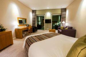 a bedroom with a large bed and a large window at Hotel de France in Saint Helier Jersey