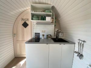 una pequeña cocina con encimera y puerta arqueada en Iglu Camp Templin, en Templin