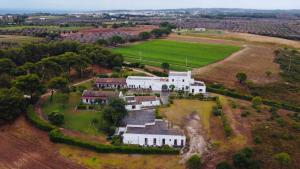 une vue aérienne sur une maison blanche dans un champ dans l'établissement Masseria Fabrizio, à Otrante