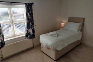 a small bedroom with a bed and a window at Bank House in Lutterworth