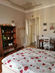 a bedroom with a large bed with red flowers on it at In centro da Laura, Via Repubblica 49 BI in Biella
