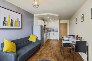 sala de estar con sofá, mesa y cocina en UR STAY Apartments Leicester, en Leicester