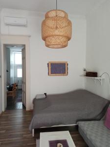 a bedroom with a bed and a chandelier at Nati Apartman in Budapest