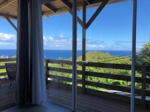 uma vista para o oceano a partir da varanda de uma casa em Alambic de Grand Anse em Petite Île