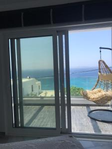 a sliding glass door with a view of the ocean at Fraskoula's Beach in Agios Stefanos