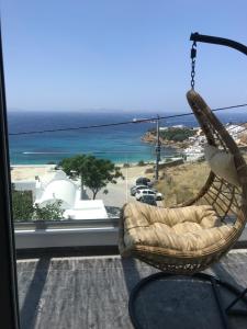 a swinging chair in a room with a view of the beach at Fraskoula's Beach in Agios Stefanos