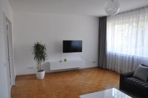 uma sala de estar com um sofá e uma televisão na parede em Ferienwohnung Hölscher em Sendenhorst