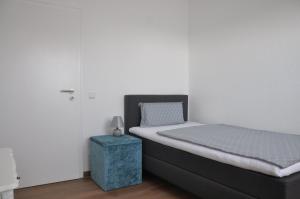 ein Schlafzimmer mit einem Bett mit einem blauen Endtisch in der Unterkunft Ferienwohnung Hölscher in Sendenhorst