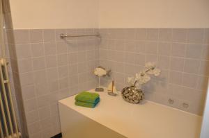 ein Badezimmer mit einem Waschbecken und einer Vase aus Blumen in der Unterkunft Ferienwohnung Hölscher in Sendenhorst