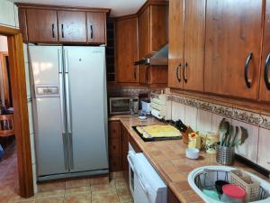 プラヤ・デ・ラス・アメリカスにあるCamison y marのキッチン(白い冷蔵庫、木製キャビネット付)
