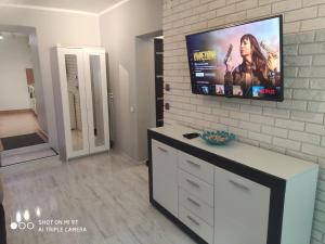 Televízia a/alebo spoločenská miestnosť v ubytovaní Apartament Tygrys