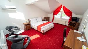 a bedroom with a bed and a desk and a television at Penzion Rosel Nové Zámky in Nové Zámky