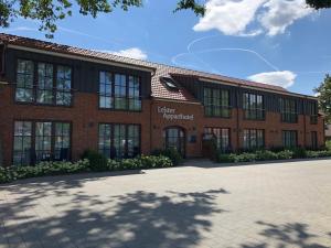 a brick building with a sign on the front of it at Leister Apparthotel in Weyhe