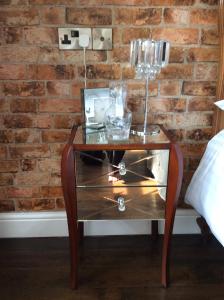 a table with glasses on top of it next to a brick wall at Holly Tree Cottage in High Etherley