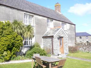 a house with a wooden table in front of it at Lellizzick Farmhouse in Padstow
