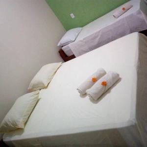 two beds in a room with towels on them at Pousada Aconchego in Mateiros