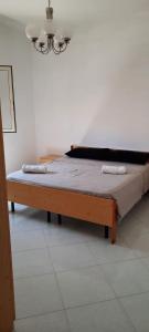 Ce lit en bois se trouve dans un dortoir doté d'un lustre. dans l'établissement villa Donato, à Raguse
