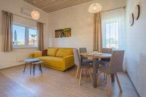 ein Wohnzimmer mit einem gelben Sofa und einem Tisch in der Unterkunft Penzion Jako Doma in Kyjov