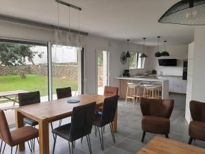 a kitchen and dining room with a wooden table and chairs at la maison des lavandières in Le Conquet