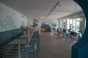 ベッラーリア・イジェア・マリーナにあるHotel Adriaのダイニングルーム(テーブル、椅子、鏡付)