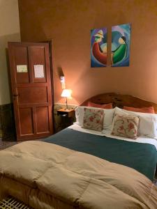 a bedroom with a bed and a door with paintings at La Posada De Juan in Cabra Corral