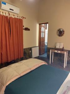 a room with a bed and a table and a window at La Posada De Juan in Coronel Moldes